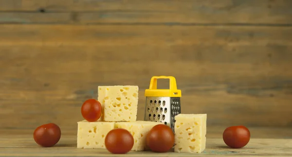 Hromada Sýrových Kostek Rajčat Miniaturním Struhadlem Dřevěném Kuchyňském Stole — Stock fotografie