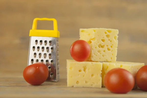 Käsewürfel Und Kirschtomaten Mit Miniaturreibe Auf Einem Holztisch Stapeln — Stockfoto
