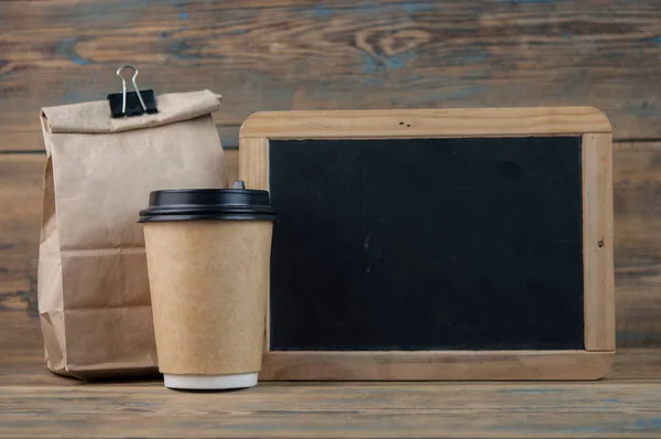 Bolsa Almuerzo Escolar Con Pizarra Blanco Sobre Fondo Madera Imagen de archivo