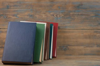 Birçok kitap ahşap arka planda. Kopya alanı ile okula dön.