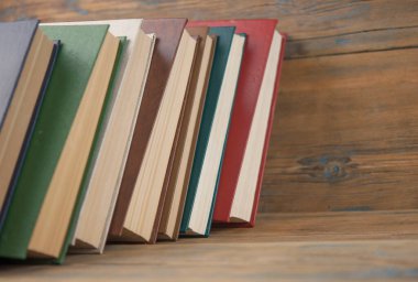 Birçok kitap ahşap arka planda. Kopya alanı ile okula dön.