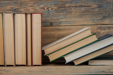 Birçok kitap ahşap arka planda. Kopya alanı ile okula dön.