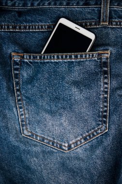 Mavi paçoz kot pantolonun arka cebindeki akıllı telefon hipster modern yaşam tarzı düzeni metin eklemek için