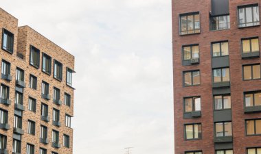 Renkli yüzlü apartman dairesi. Binanın üzerinde bir sürü kare cam pencere ve çiçek olan modern minimalist mimari.