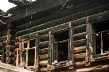 Yangından sonra ahşap ev. Kütüklerdeki kömürleri. Evin külleri yangından. Yanmış kır evi..