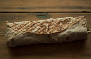 Ev konseptinde mutfak masasında tavuk dürümü pişirme süreci. Ev yapımı kebap yakın çekim. Taze lavaş ya da içinde besleyici maddeler olan bir rulo shawarma sandviçi..