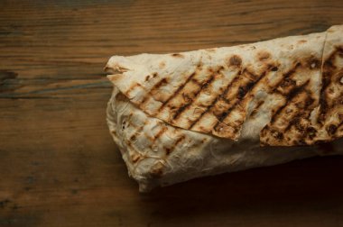 Ev konseptinde mutfak masasında tavuk dürümü pişirme süreci. Ev yapımı kebap yakın çekim. Taze lavaş ya da içinde besleyici maddeler olan bir rulo shawarma sandviçi..