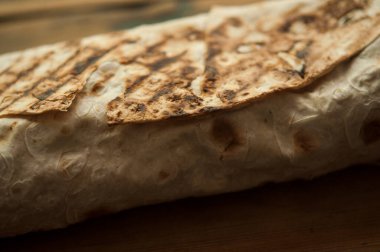 Ev konseptinde mutfak masasında tavuk dürümü pişirme süreci. Ev yapımı kebap yakın çekim. Taze lavaş ya da içinde besleyici maddeler olan bir rulo shawarma sandviçi..