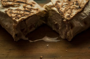 Ev konseptinde mutfak masasında tavuk dürümü pişirme süreci. Ev yapımı kebap yakın çekim. Taze lavaş ya da içinde besleyici maddeler olan bir rulo shawarma sandviçi..