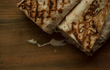 Ev konseptinde mutfak masasında tavuk dürümü pişirme süreci. Ev yapımı kebap yakın çekim. Taze lavaş ya da içinde besleyici maddeler olan bir rulo shawarma sandviçi..