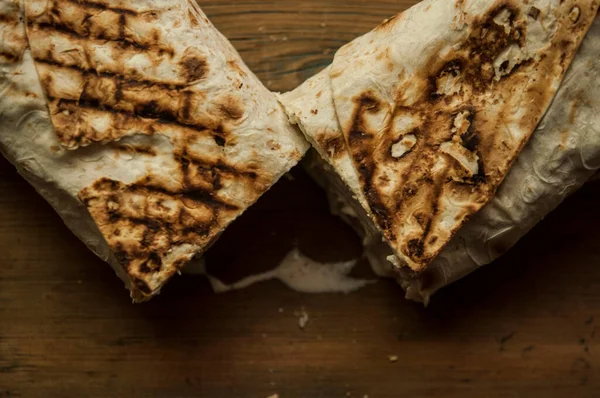 Ev konseptinde mutfak masasında tavuk dürümü pişirme süreci. Ev yapımı kebap yakın çekim. Taze lavaş ya da içinde besleyici maddeler olan bir rulo shawarma sandviçi..