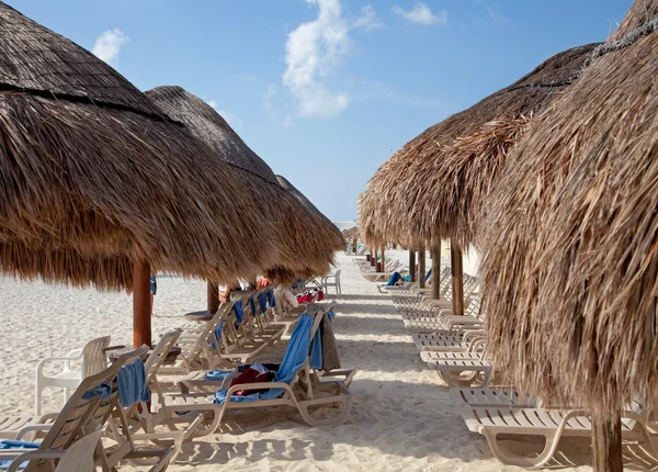 Stro parasols en zonnebaden stoelen op het strand — Stockfoto