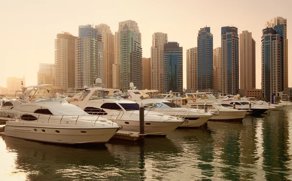 Rascacielos y yates en Dubai Marina durante la puesta del sol — Foto de Stock