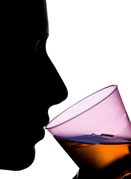 Geïsoleerde silhouet van een gezicht drinken oranje vloeistof — Stockfoto