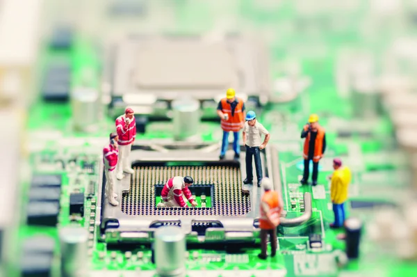 Little workers repairing motherboard — Stock Photo, Image