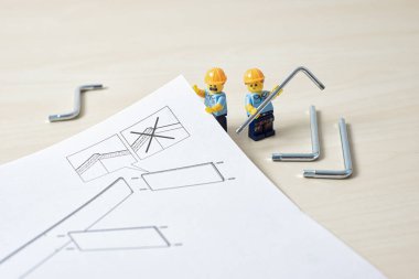 Workers reading instruction to assemble furniture. DIY concept. Illustrative editorial. December 25, 2021