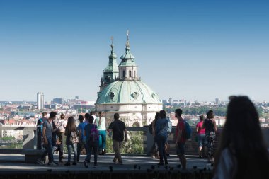 Prag, Çek Cumhuriyeti - 26 Mayıs 2019: Prag kalesinin duvarlarında Aziz Nicholas Kilisesi 'ne bakan turistler