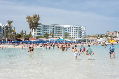 Agia Napa, Kıbrıs - 07 Nisan 2018: Nissi plajında yürüyen ve yıkanan turistler