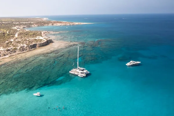 Kayalık Sahil Kenarındaki Masmavi Sulardaki Teknenin Havadan Görüntüsü Kıbrıs — Stok fotoğraf
