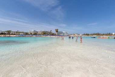 Ayia Napa, Kıbrıs - 07 Nisan 2018: Nissi plajında yürüyen ve yıkanan turistler