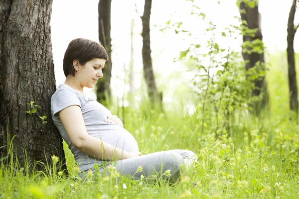 Donna incinta rilassante nel parco — Foto Stock