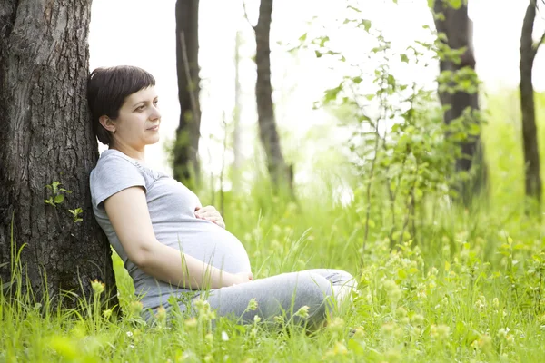 Donna incinta rilassante nel parco — Foto Stock