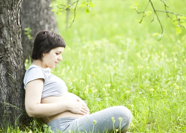 Donna incinta rilassante nel parco — Foto Stock