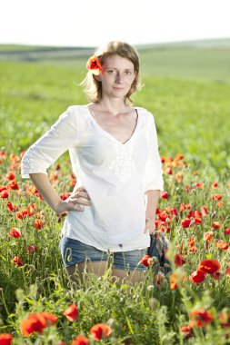 Girl jumping in red poppies field