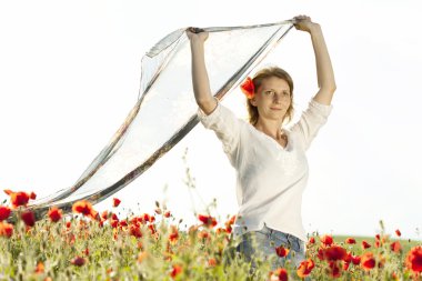 Girl jumping in red poppies field