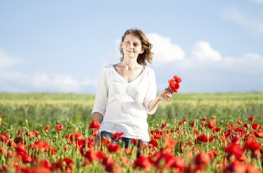 Girl jumping in red poppies field