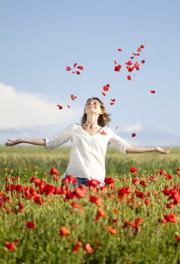 Girl jumping in red poppies field