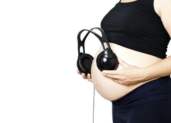 Pregnant woman with headphones on bump — Stock Photo, Image