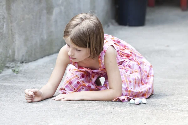 Back to school concept - Photo of girl writing with chalk on the schoolyard — Stock Photo, Image