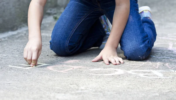 Back to school concept - Photo of girl writing with chalk on the schoolyard — Stock Photo, Image