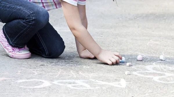 Back to school concept - Photo of girl writing with chalk on the schoolyard Stock Photo