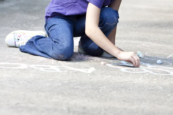 Back to school concept - Photo of girl writing with chalk on the schoolyard Royalty Free Stock Photos