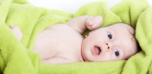 緑のタオルで覆われている幸せな赤ちゃん — Stockfoto