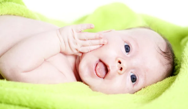 Gelukkig baby bedekt met groene handdoek — Stockfoto