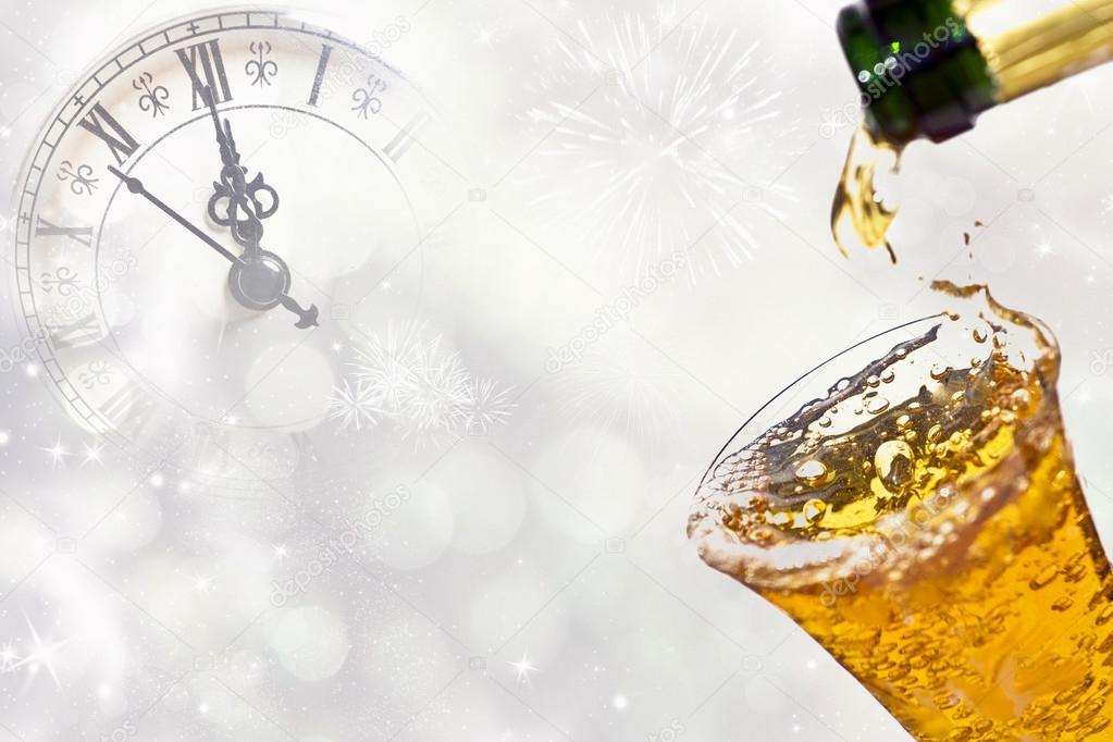 Pouring champagne against holiday lights and clock close to midnight