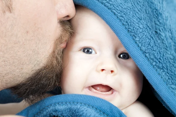 Pai beijo 3 meses de idade sorrindo bebê menina escondendo em manta azul — Fotografia de Stock