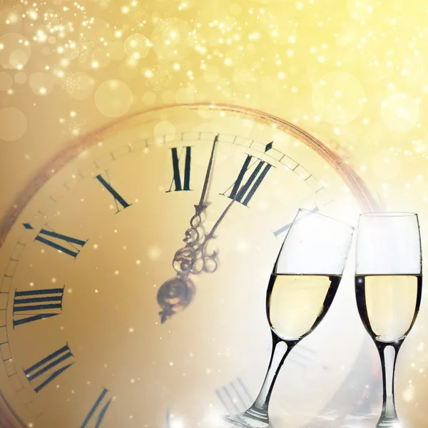 Glasses with champagne and clock close to midnight — Stock Photo, Image