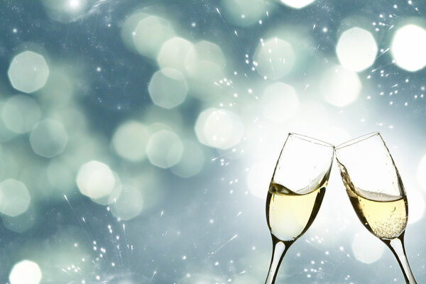 Glasses with champagne against holiday lights