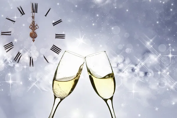 Glasses with champagne against old clock — Stock Photo, Image