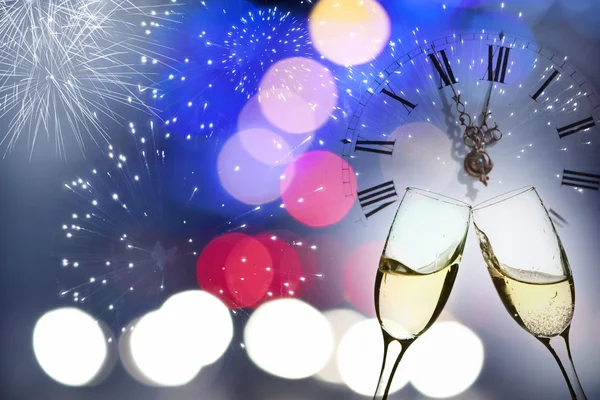 Glasses with champagne against fireworks and clock — Stock Photo, Image