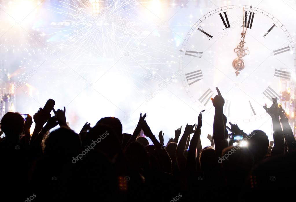 Clock close to midnight, fireworks and crowd waiting for New yea