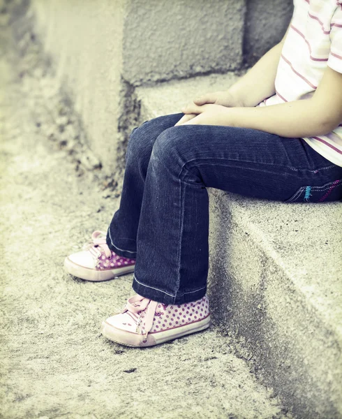 Girl sitting in the schoolyard Royalty Free Stock Images