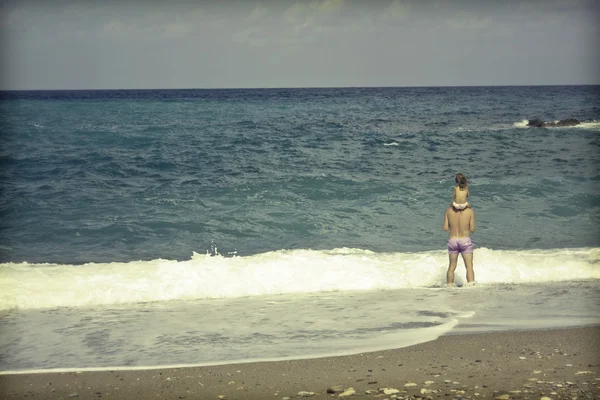 Förälder med sin dotter på stranden — Stockfoto