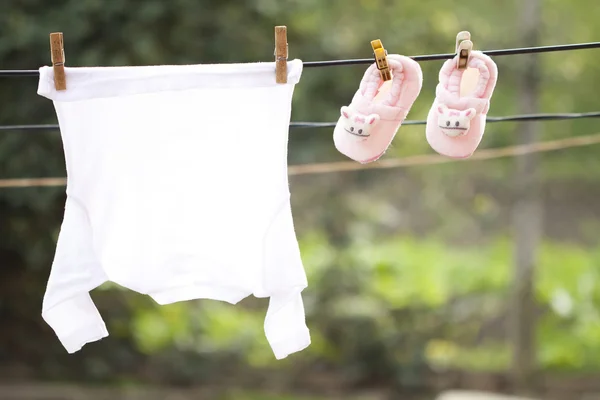 Vêtements de bébé suspendus sur la corde à linge — Photo