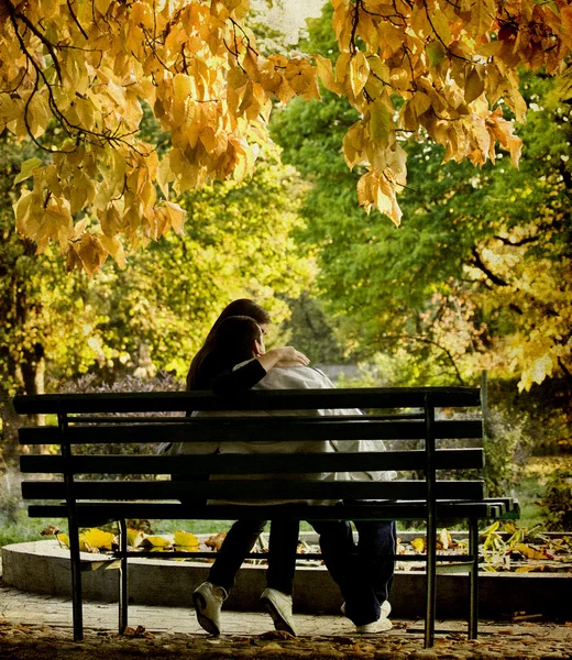 Casal romântico sentado no parque de outono — Fotografia de Stock