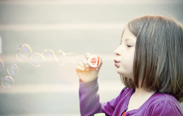 Giovane ragazza soffiando bolle di sapone — Foto Stock